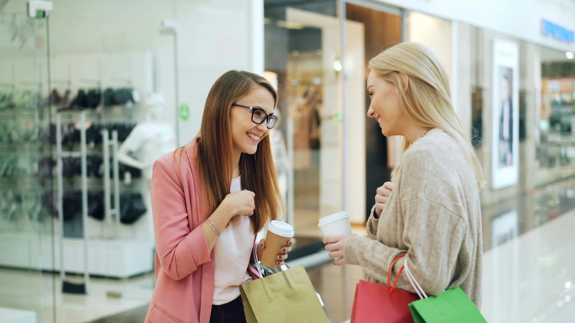 Due amiche fanno shopping con caffè e borse